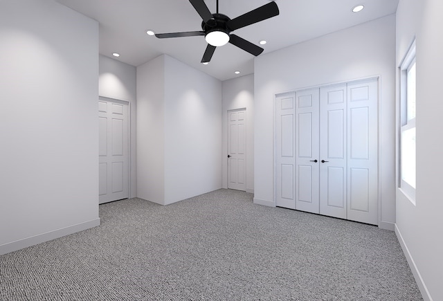 unfurnished bedroom with light carpet, multiple windows, and ceiling fan