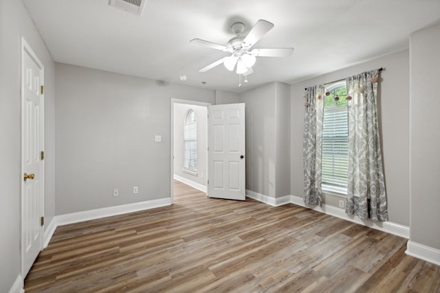 empty room with ceiling fan and wood-type flooring