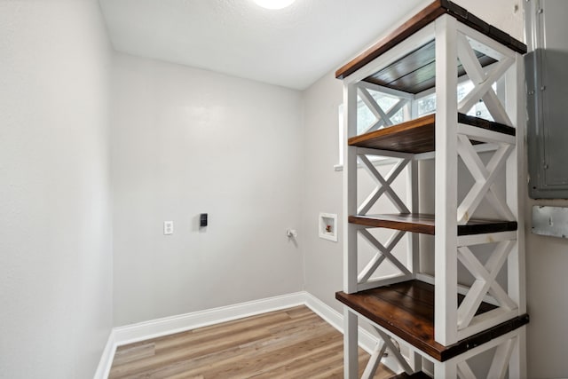 laundry area featuring washer hookup, wood-type flooring, a textured ceiling, and electric panel