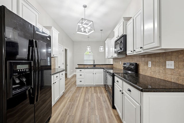 kitchen with sink, black appliances, decorative light fixtures, light hardwood / wood-style floors, and white cabinetry