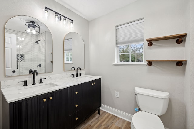 bathroom with toilet, hardwood / wood-style flooring, plenty of natural light, and tiled shower