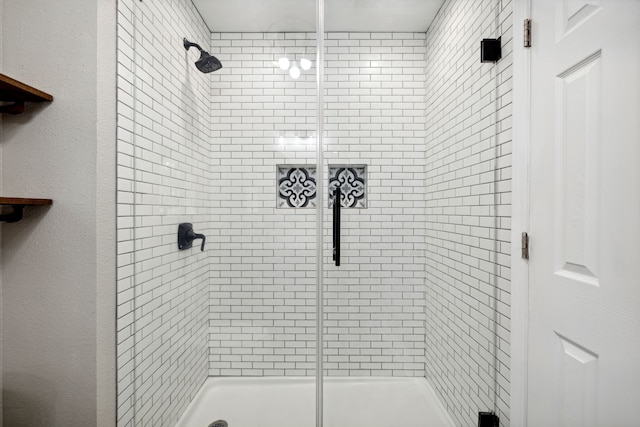 bathroom featuring a shower with door