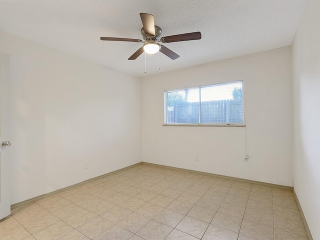 tiled spare room featuring ceiling fan and a textured ceiling