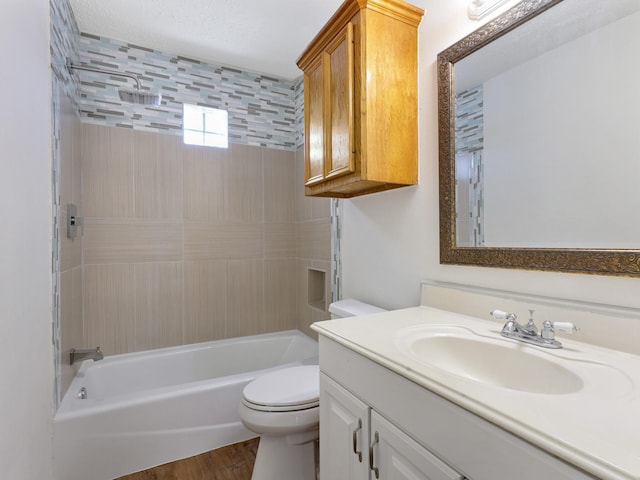 full bathroom featuring tiled shower / bath, a textured ceiling, hardwood / wood-style flooring, toilet, and vanity