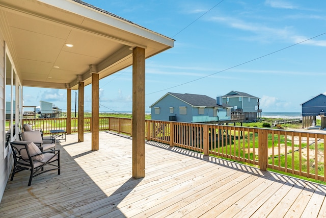 wooden terrace with a lawn and a water view