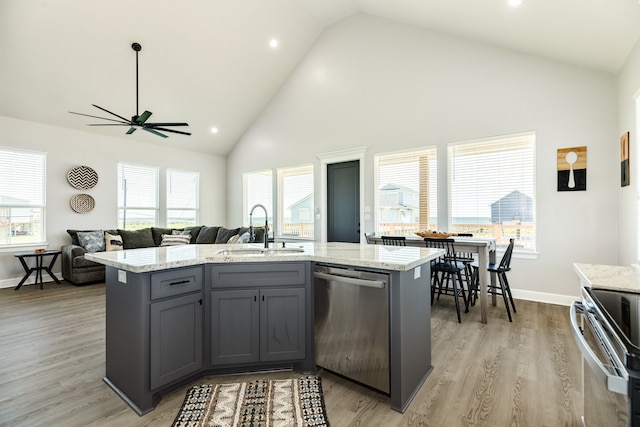 kitchen with high vaulted ceiling, stainless steel appliances, sink, and plenty of natural light