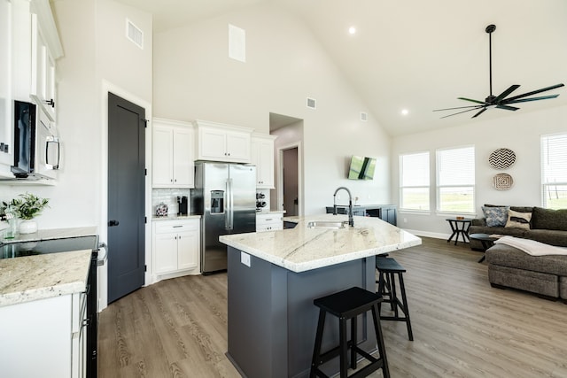 kitchen featuring white cabinets, a kitchen island with sink, stainless steel appliances, and sink