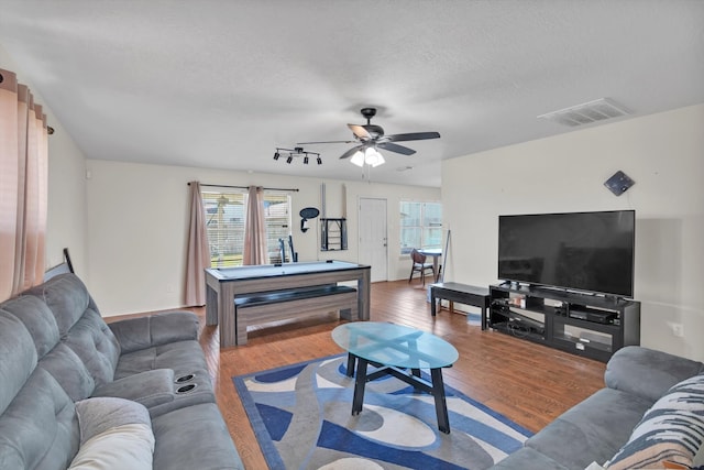 living room with ceiling fan, wood-type flooring, and a textured ceiling