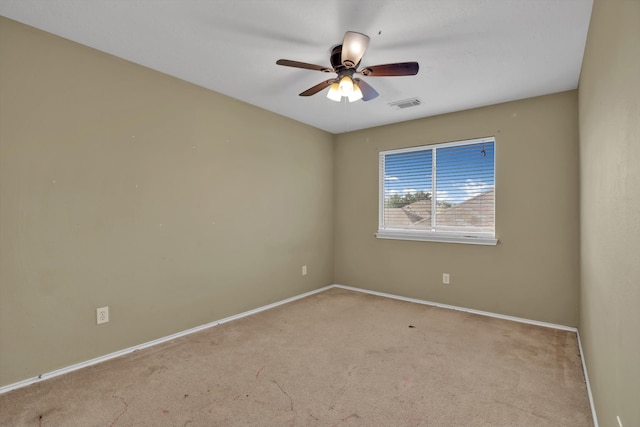 carpeted spare room with ceiling fan