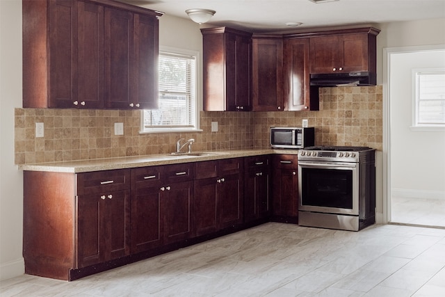 kitchen with decorative backsplash, appliances with stainless steel finishes, and sink