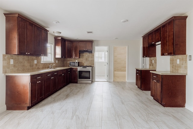 kitchen featuring backsplash, appliances with stainless steel finishes, and sink