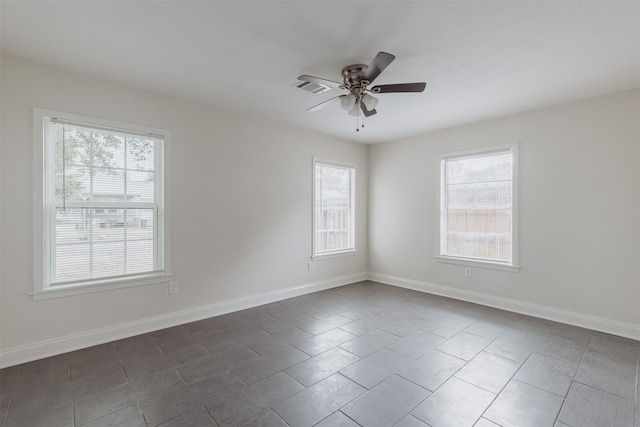 tiled empty room featuring a wealth of natural light and ceiling fan