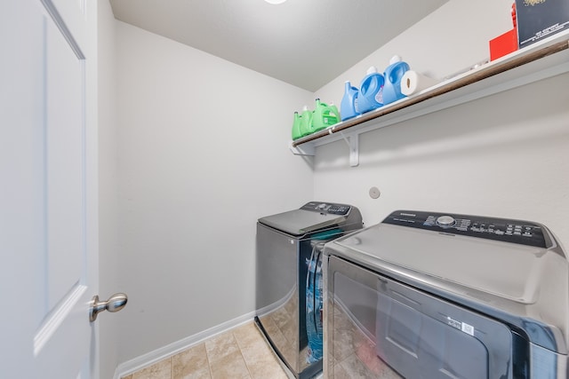 washroom with light tile patterned flooring and washing machine and dryer