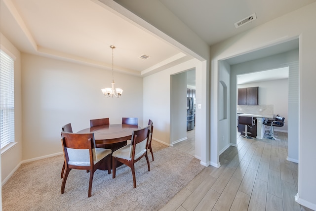 dining room featuring a chandelier, light wood-type flooring, and plenty of natural light