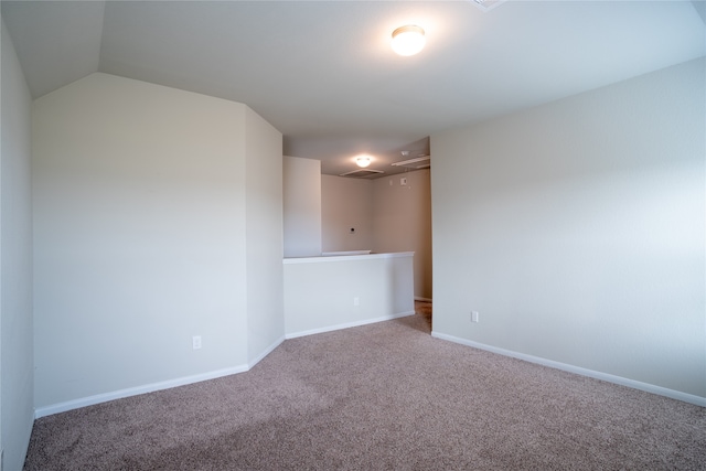 carpeted empty room with lofted ceiling