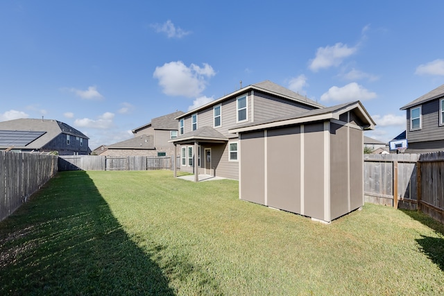 rear view of property featuring a storage shed and a lawn