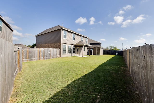 rear view of property with a yard and a shed