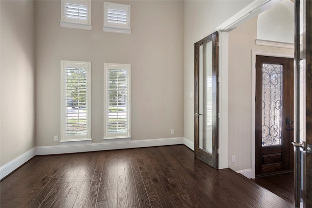 entrance foyer featuring french doors, dark wood-type flooring, and a high ceiling