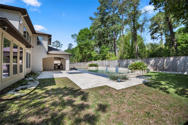 view of yard with an outdoor kitchen, a patio area, and a fenced in pool