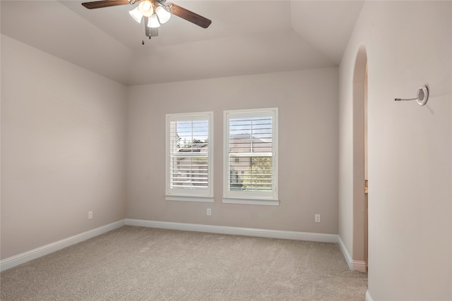 empty room with light carpet, vaulted ceiling, and ceiling fan