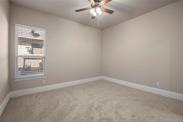 spare room with ceiling fan and light colored carpet