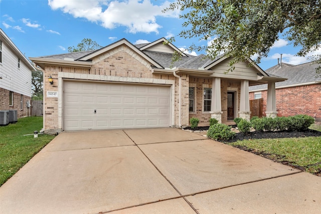 view of front of home featuring a garage, central AC, and a front yard