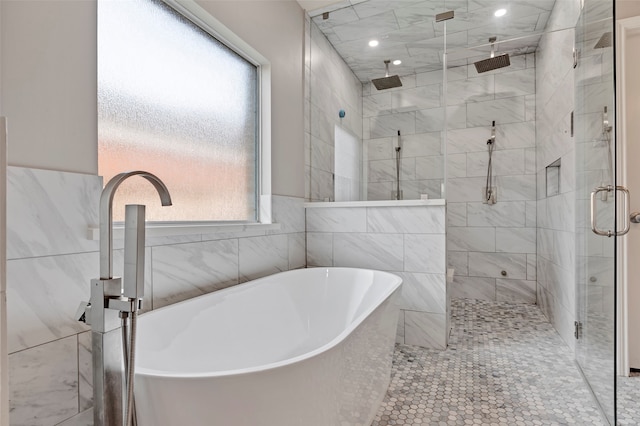 bathroom with shower with separate bathtub and tile walls