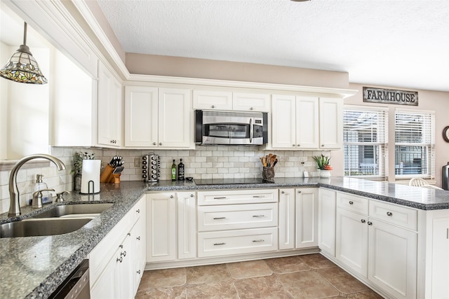 kitchen with white cabinetry, backsplash, appliances with stainless steel finishes, and sink