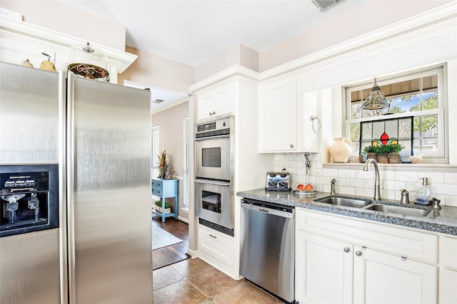 kitchen featuring light hardwood / wood-style flooring, sink, white cabinets, appliances with stainless steel finishes, and tasteful backsplash