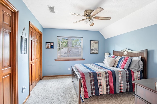 carpeted bedroom featuring lofted ceiling, a textured ceiling, a closet, and ceiling fan