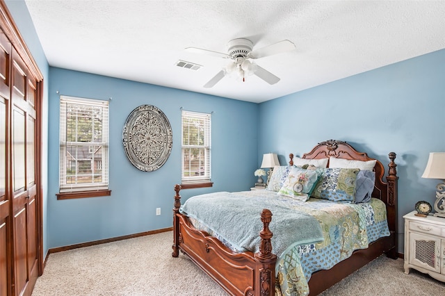 carpeted bedroom with a closet, a textured ceiling, and ceiling fan