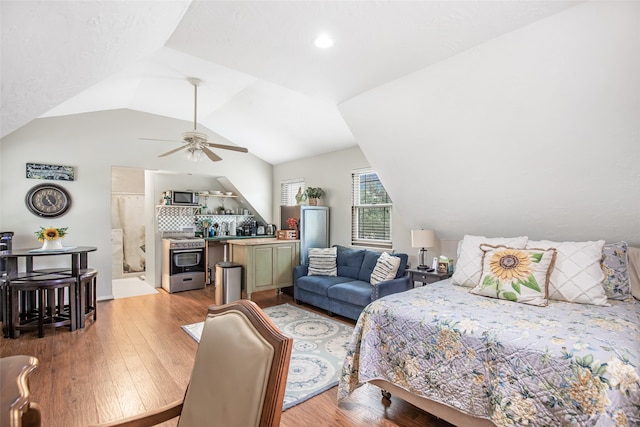 bedroom featuring ceiling fan, lofted ceiling, and light wood-type flooring