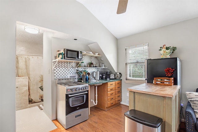 kitchen with lofted ceiling, tasteful backsplash, ceiling fan, light hardwood / wood-style floors, and stainless steel appliances