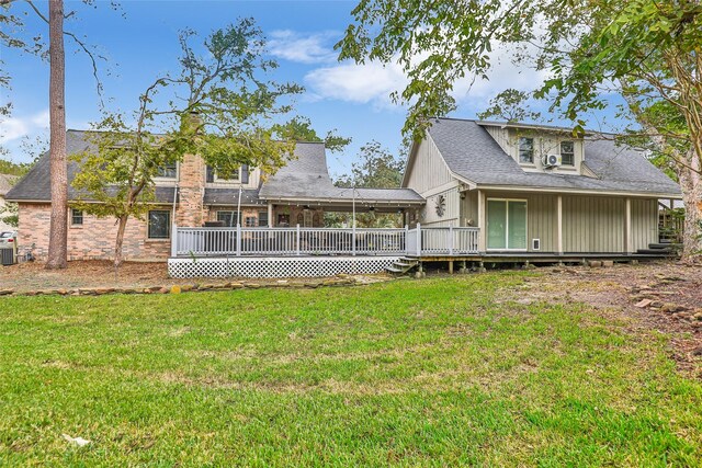 back of property with a yard, a deck, and cooling unit