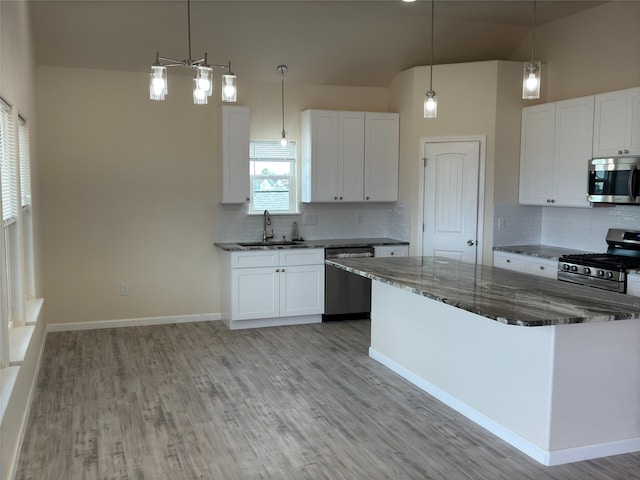 kitchen featuring stainless steel appliances, pendant lighting, and white cabinets