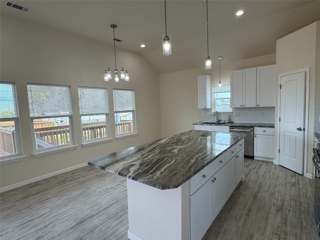 kitchen with sink, white cabinets, dishwasher, and a kitchen island