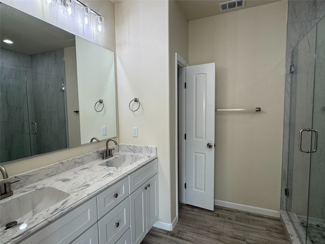 bathroom with walk in shower, vanity, and wood-type flooring