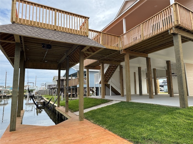 dock area featuring a lawn, a water view, and a patio