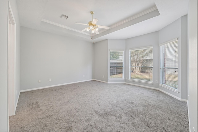 carpeted spare room featuring a raised ceiling, crown molding, and ceiling fan