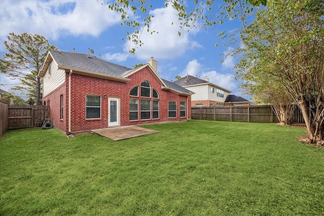 back of house with a lawn and a patio