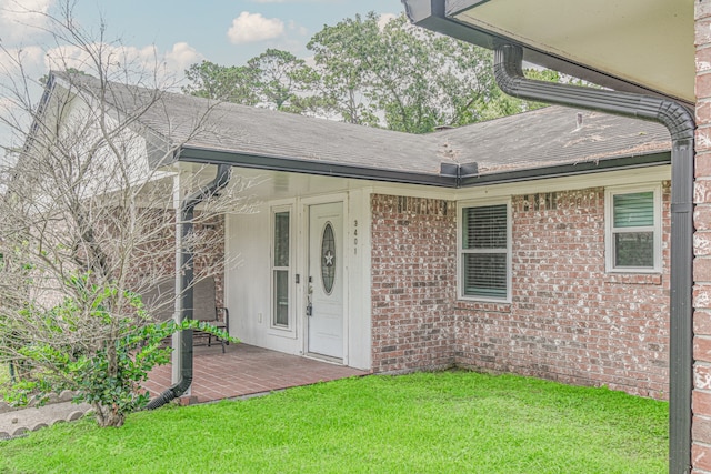 property entrance with a lawn