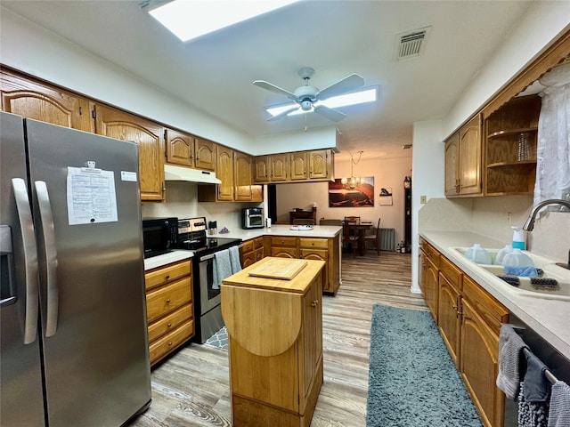 kitchen with sink, light hardwood / wood-style flooring, stainless steel appliances, and a center island