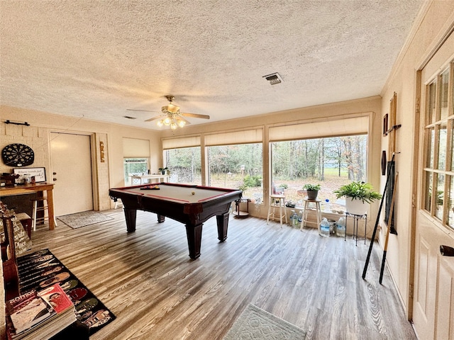 recreation room with a textured ceiling, hardwood / wood-style flooring, billiards, and ceiling fan