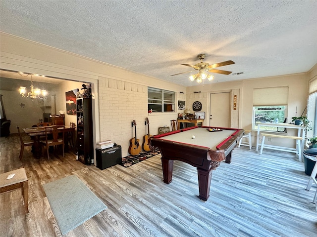 playroom with a textured ceiling, wood-type flooring, ceiling fan with notable chandelier, and billiards