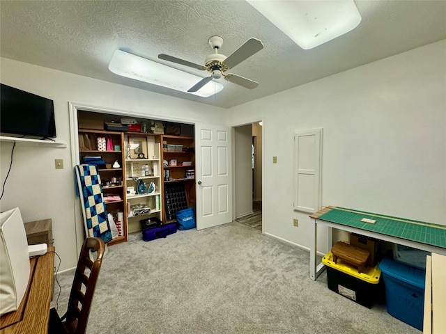 playroom with ceiling fan, carpet flooring, and a textured ceiling