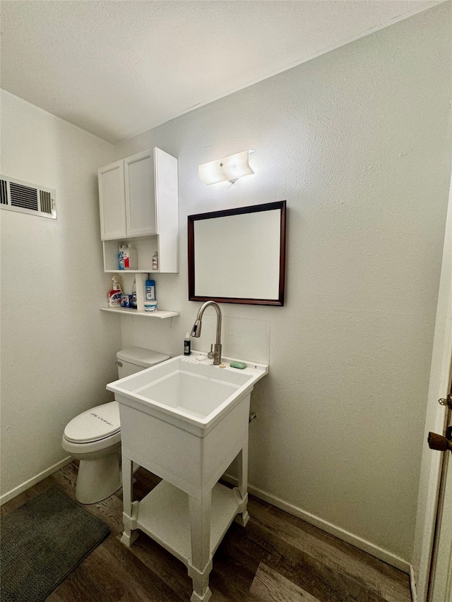 bathroom featuring wood-type flooring and toilet