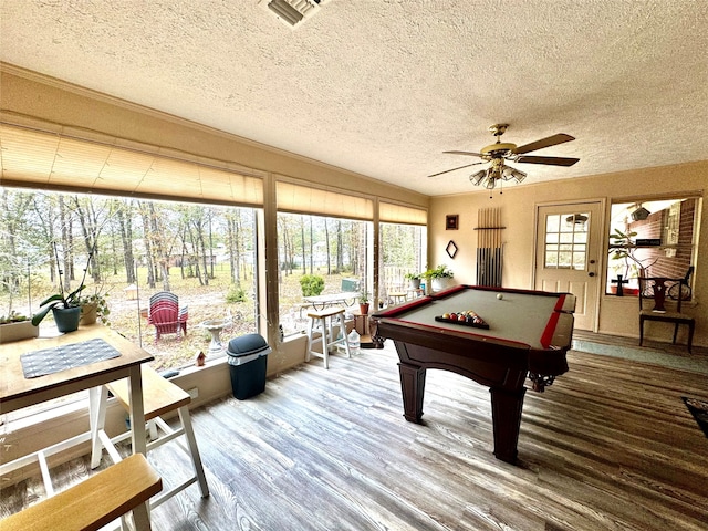 recreation room with ceiling fan, hardwood / wood-style flooring, a textured ceiling, and a wealth of natural light