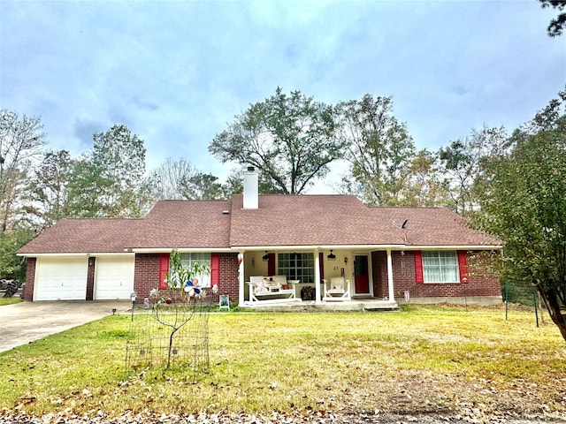 single story home featuring a front lawn, covered porch, and a garage