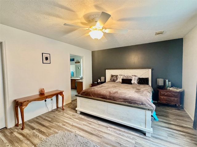 bedroom with hardwood / wood-style floors, a textured ceiling, and ceiling fan