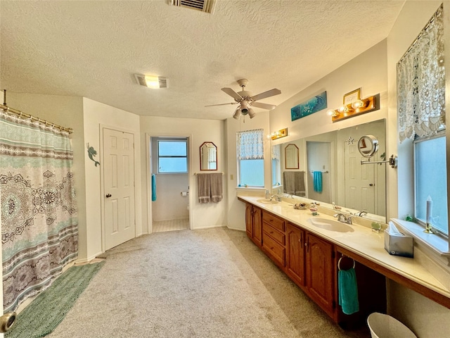 bathroom featuring vanity, a textured ceiling, and ceiling fan